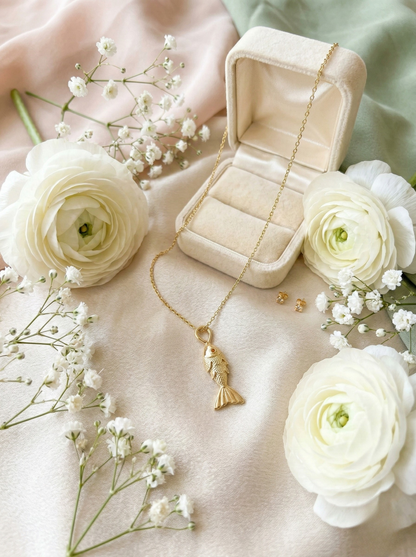 Golden Aquatic Elegance: Fish Pendant on Marble